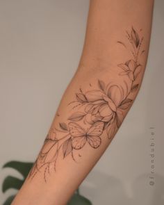 a woman's arm with flowers and leaves on the left side of her body