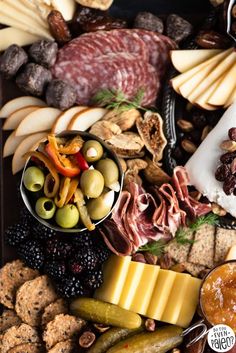 an assortment of cheeses, crackers, and meats on a platter