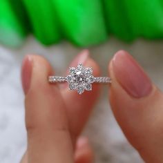 a person holding a diamond ring in their hand