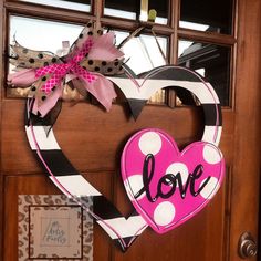 a heart shaped door hanger with the word love painted on it