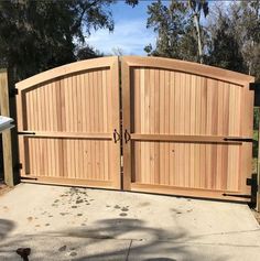 a large wooden gate in the middle of a driveway