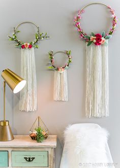 three wall hangings decorated with flowers and greenery