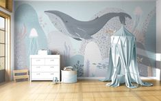 a child's room decorated in blue and white with a whale mural on the wall