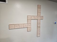 a cross made out of scrabble tiles on the wall