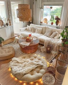 a living room filled with lots of furniture and lights on the floor in front of windows