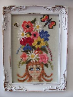 a cross stitch picture frame with flowers and butterflies on it