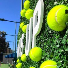 a tennis court wall with green balls on it