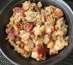 a bowl filled with rice and meat on top of a table