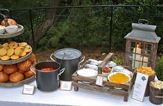 a table topped with lots of food next to a forest