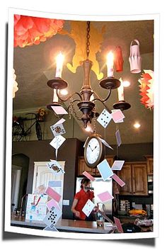 a chandelier hanging from the ceiling in a kitchen with cards stuck to it