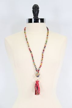 This relaxed style is oh-so-casual when worn alone and makes the perfect boho statement when layered. Colorful, repurposed Kantha textile beads alternate with tiny gold beads to form a long strand that is finished with a statement bead, textured gold ring and tassel.Each piece is made from recycled Kantha textiles, so colors and patterns are all one-of-a-kind and will vary. Measures 32″ long. Sustainably handmade by women artisans in India. Handmade Lariat Tassel Necklace, Bohemian Tassel Necklace With Dangling Beads For Beach, Adjustable Beaded Long Tassel Necklace, Bohemian Long Tassel Necklace With Dangling Beads, Handmade Tassel Necklace For Beach, Bohemian Tassel Necklace With Beaded Chain, Adjustable Bohemian Long Necklace With Tassels, Adjustable Multicolor Tassel Necklace With Round Beads, Adjustable Tassel Necklace For Beach