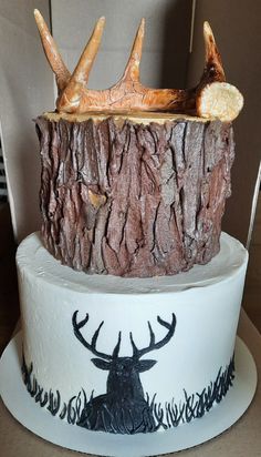 two tiered cake decorated with deer heads and antlers on it's sides