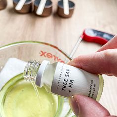 a person is pouring olive oil into a glass bowl