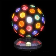 a colorful light up ball sitting on top of a metal stand with lights around it