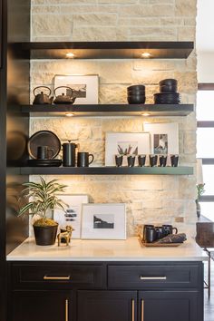 a kitchen with black cabinets and shelves filled with pots, pans and other items