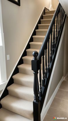 there is a black railing on the stairs in this house with beige carpet and white walls