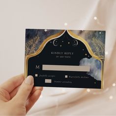 a person holding up a business card with an image of a night sky and stars on it