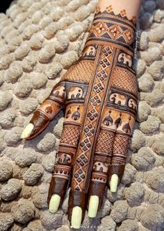 a woman's hand with hennap on it and an elephant pattern painted on the palm