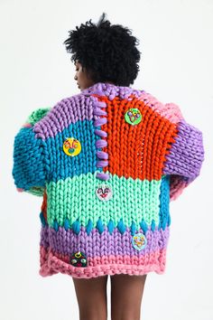 the back of a woman's colorful sweater with buttons on her shoulders and arms