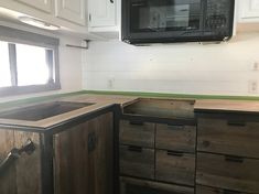 a kitchen area with cabinets and a microwave above the stove in a mobile home that's being built