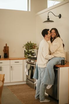 a man and woman are hugging in the kitchen