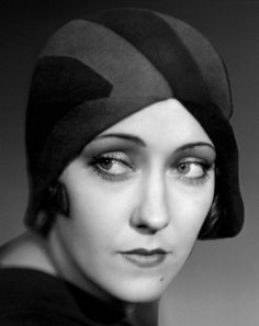 a black and white photo of a woman wearing a hat