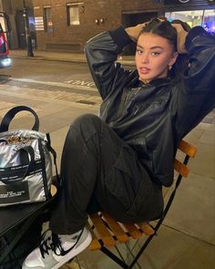 a woman sitting in a chair next to a bag