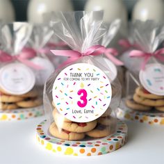 some cookies are wrapped in plastic bags and tied with pink ribbon to give them the number three