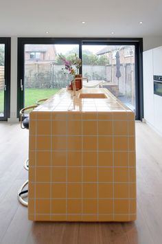 an orange tiled counter top in a kitchen next to a sliding glass door that leads outside