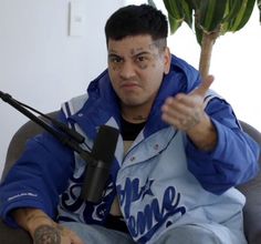 a man sitting on top of a couch with a microphone in front of his face