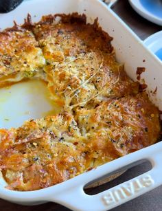 a casserole dish with cheese and herbs in it