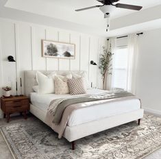 a bedroom with a bed, rug and ceiling fan