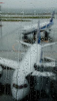 an airplane is seen through the rain covered window