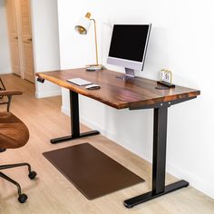 a desk with a computer on it and a mouse pad next to it in front of a white wall