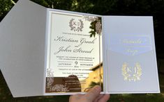 a person holding an open wedding card in their hand