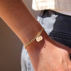 14k gold fill bold link chain Demi Alexandra Bracelet featuring two gold fill disks with a heart and an S, worn by a model wearing black jeans and a white top Gold Engraved Charm Bracelet, Customizable Gold Name Bracelet For Friendship, Classic Gold Name Bracelet For Friendship, Everyday Gold Engraved Chain Bracelet, Gold Engraved Chain Bracelet For Everyday, Everyday Yellow Gold Personalized Bracelets, Gold Round Chain Bracelet For Friendship, Gold Hypoallergenic Name Bracelet, Gold Engraved Charm Bracelet For Everyday