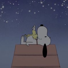 a cartoon character laying on top of a roof with stars in the sky behind him