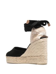 Castañer Carina Wedge Espadrilles - Farfetch Chic Wedge Sandals With Woven Sole And Round Toe, Chic High Heel Espadrilles With Woven Sole, Black Closed Toe Straw Sandals, Black Wedge Sandals With Textured Sole, Chic High Heel Straw Espadrilles, Black Closed-toe Straw Espadrilles, Black Closed Toe Straw Espadrilles, Black Straw Wedge Heel Espadrilles, Black Espadrille Heels For Beach