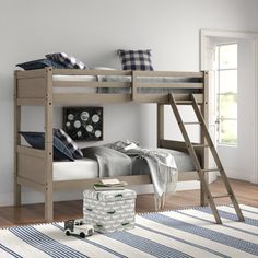 a wooden bunk bed sitting on top of a hard wood floor next to a window