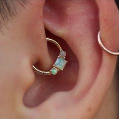 a close up of a person's ear with an opal in the middle