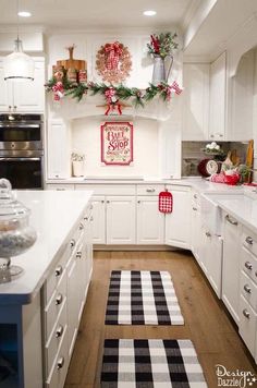 a kitchen decorated for christmas with white cabinets and black and white checkered runner rug