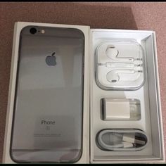 an iphone in its box with ear buds and charger