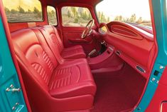 the interior of a red and blue truck with its door open to show it's leather seats