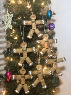 a small christmas tree decorated with corks and gingerbread man ornament hanging from it