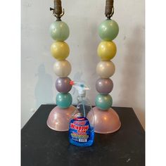 a bottle of liquid sitting on top of a table next to a lamp with balloons