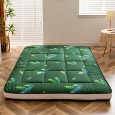 a green mattress sitting on top of a wooden floor