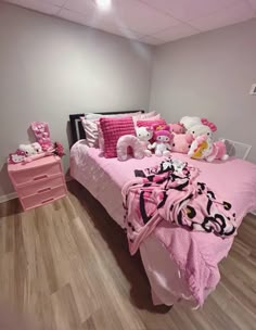 a bedroom with pink bedding and teddy bears