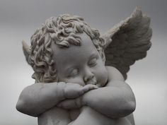 an angel statue with its hands on his chest