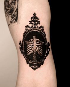 a skeleton in a frame tattoo on the back of a woman's right leg