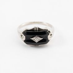 Hi. This is a pretty onyx ring with diamond accents in 10k white gold. The onyx stone measures approximately 7.5x14mm. At the center is a diamond accent. It is marked 10k on the inside of the ring. The ring finger size is 7.25. Sorry, we d not resize rings. The weight of the ring with stones is 3.4 grams. Thanks for looking. Classic White Gold Onyx Rings, Classic Sterling Silver Enamel Ring For Anniversary, Formal Onyx Diamond Ring In Fine Jewelry Style, Formal Onyx Diamond Ring Fine Jewelry, Classic Formal Enamel Ring, Black Oval Enamel Ring For Formal Occasions, Classic Silver Enamel Ring For Formal Occasions, Black Oval Enamel Ring, Classic White Gold Rings With Black Enamel